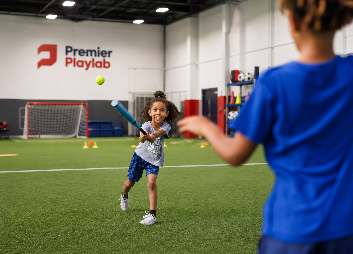 Children playing baseball indoors at Premier Playlab sports facility